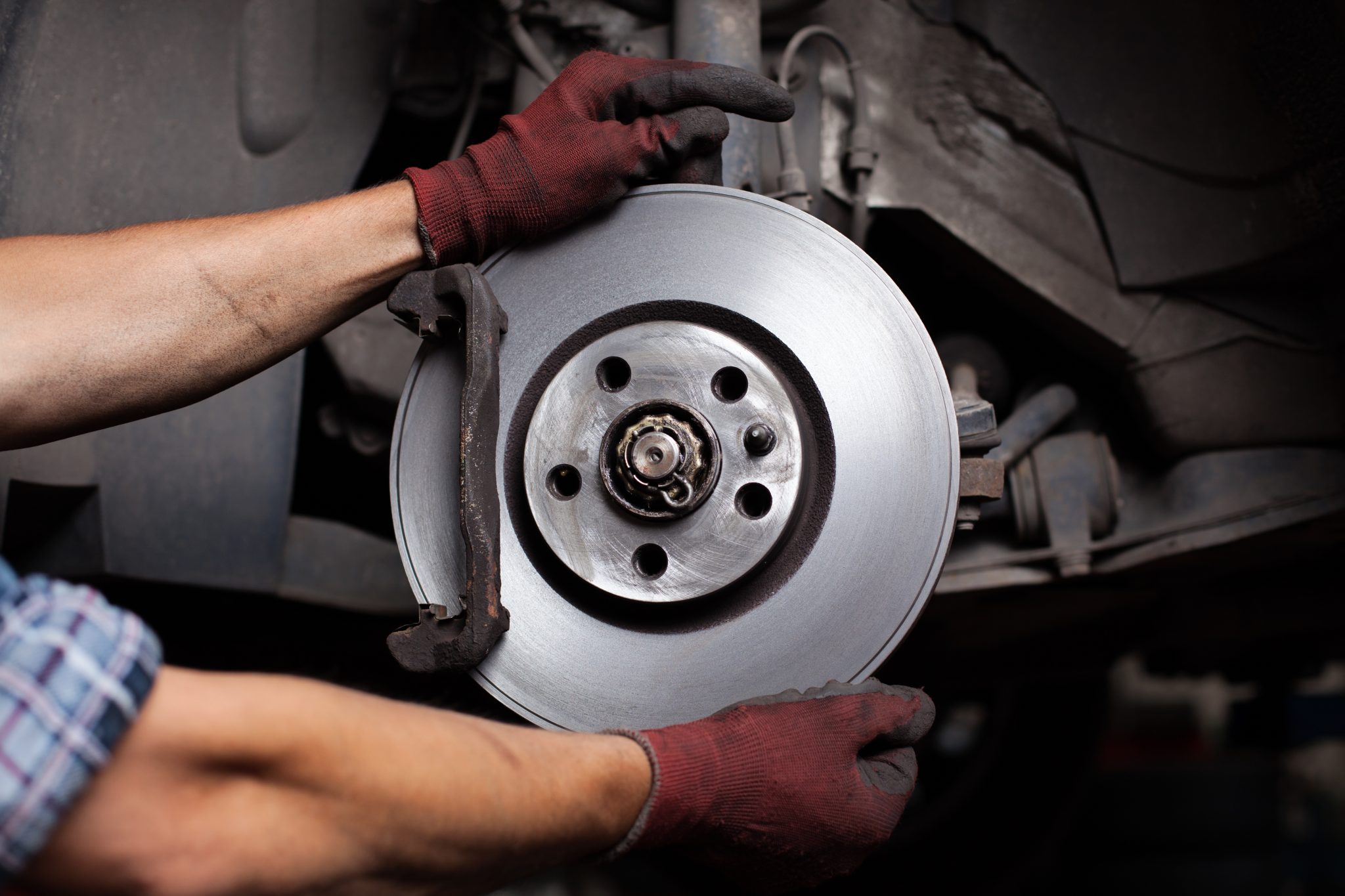 Car Mechanic Repairing Brakes On Car